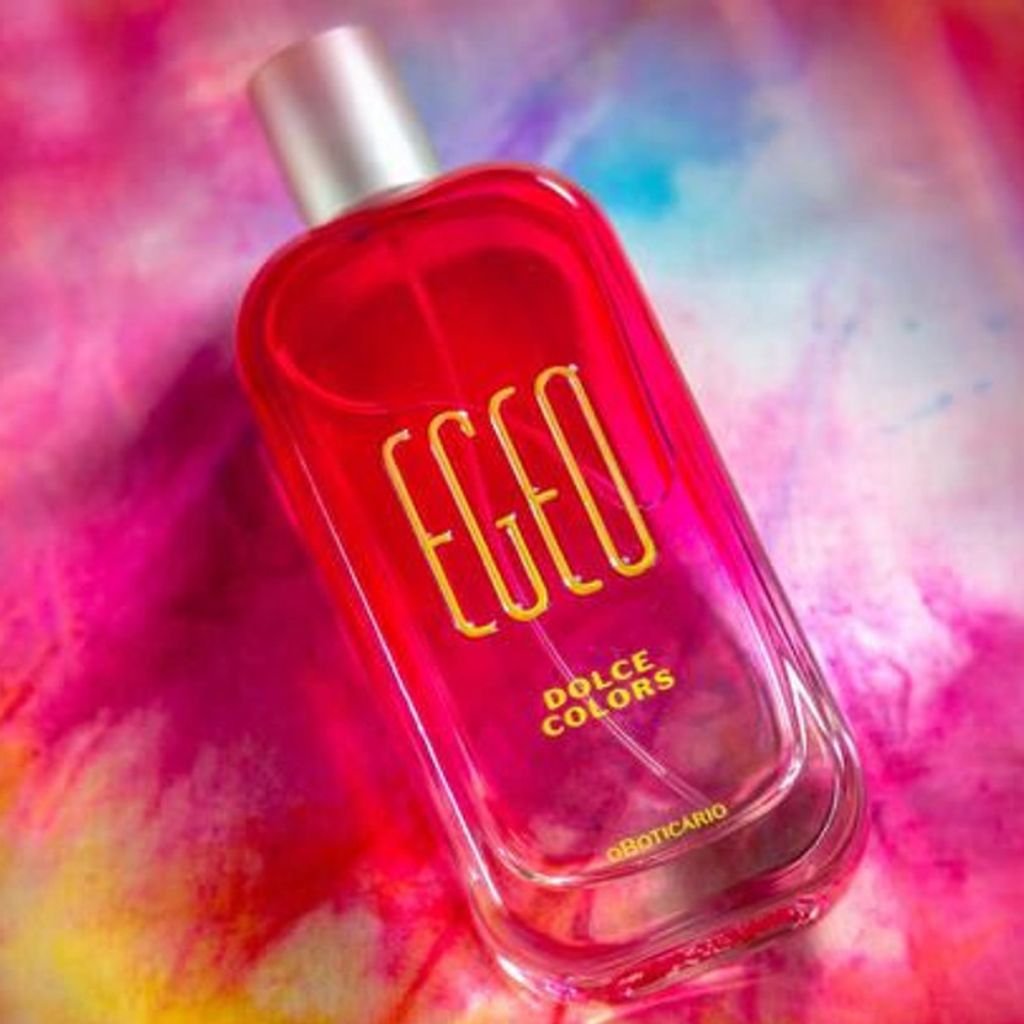 Egeo Dolce, de O Boticário, sobre uma superfície colorida com predominância do rosa, cor do perfume.